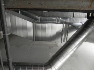 Montaje de conductos de ventilación para sótanos  en interior patio de luces, mediante chapa galvanizada y trabajos verticales.
